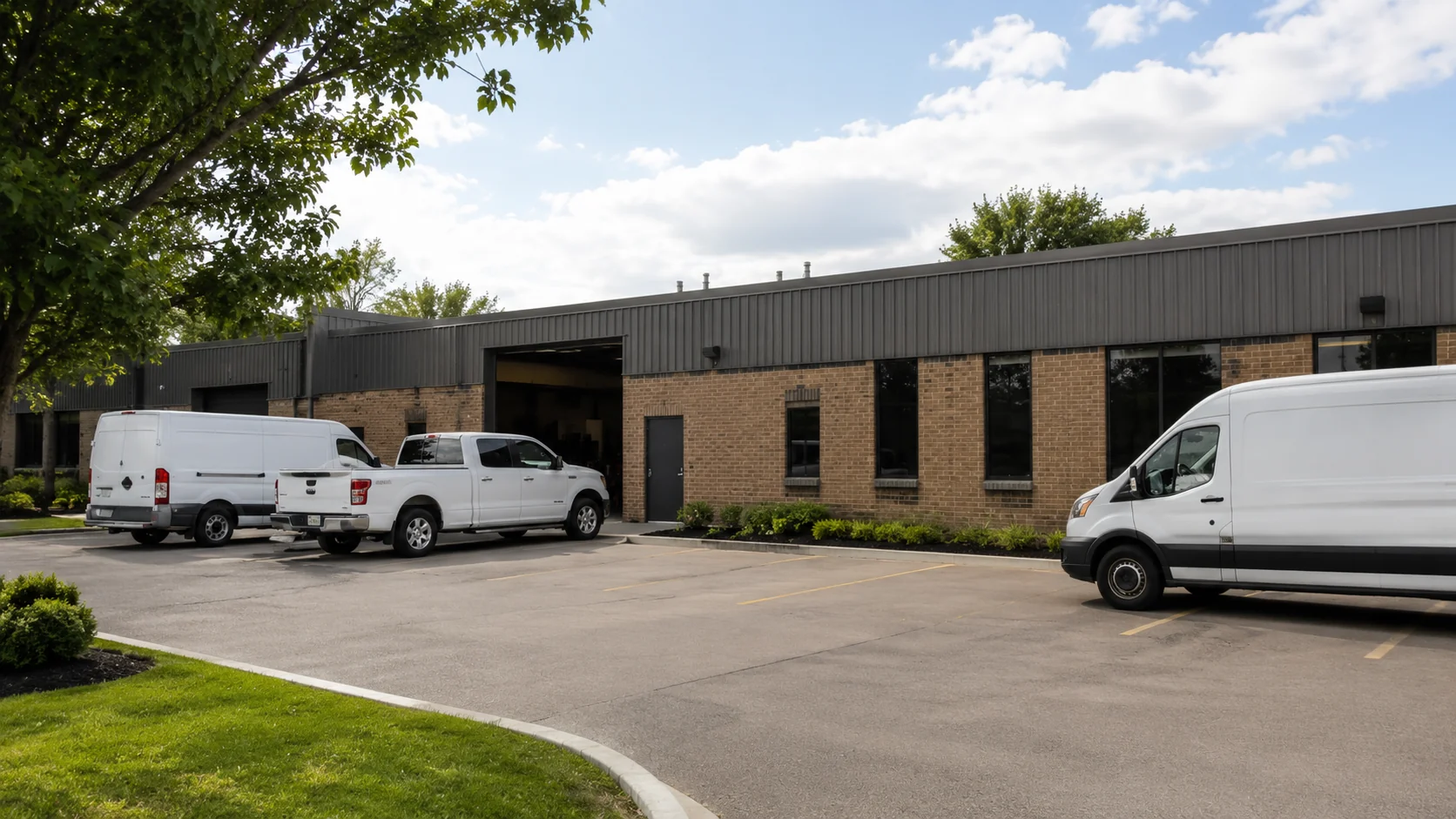 Commercial building with a fleet of white vans in the lot